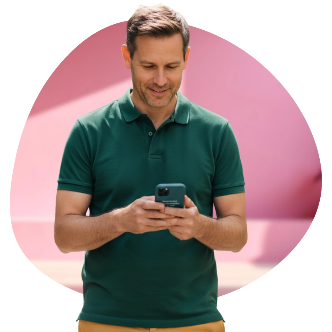 Middle-aged professional standing and looking down at his phone while reviewing financial information