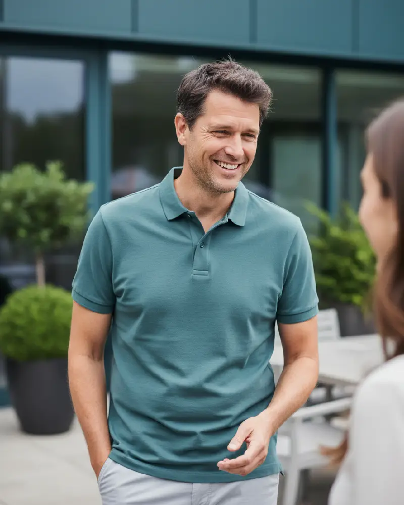 Casually dressed man in a polo shirt and chinos speaking with someone just off camera about finance options